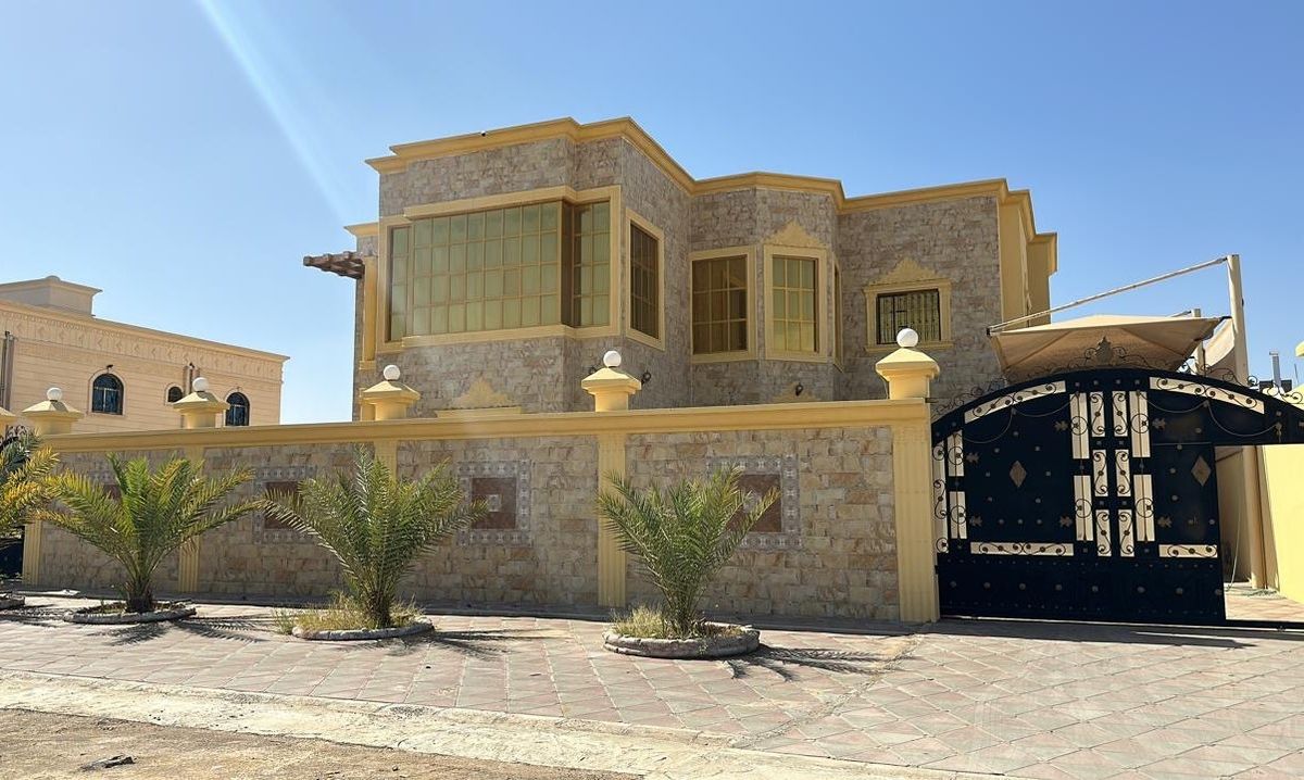 Completed two-storey stone-clad villa with boundary wall and gate in Oman